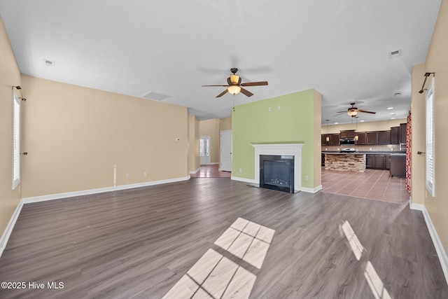 unfurnished living room with wood-type flooring and ceiling fan