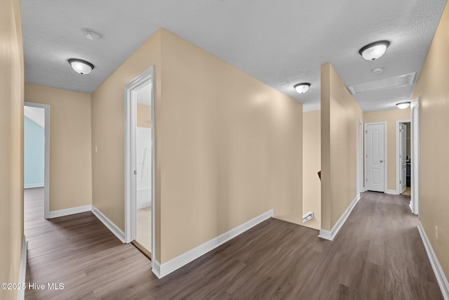 hall with wood-type flooring and a textured ceiling