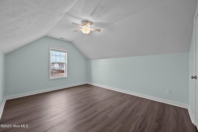 additional living space with dark hardwood / wood-style flooring, ceiling fan, lofted ceiling, and a textured ceiling