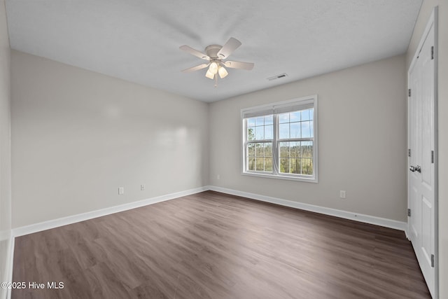 spare room with ceiling fan and dark hardwood / wood-style flooring