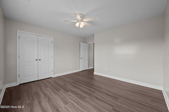 unfurnished bedroom with ceiling fan, dark hardwood / wood-style flooring, and a closet