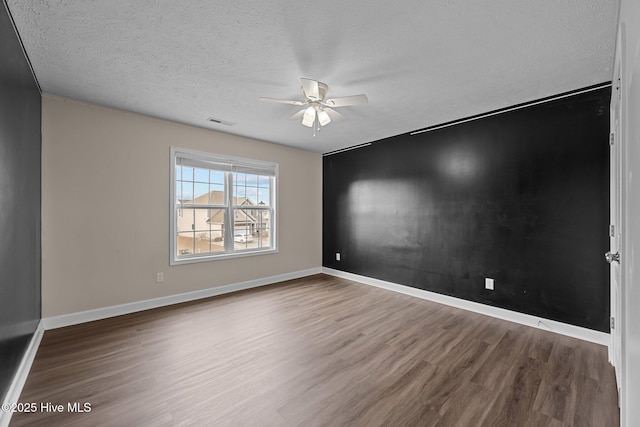 empty room with hardwood / wood-style floors, a textured ceiling, and ceiling fan