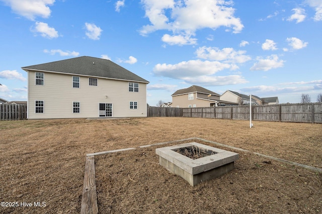 back of property featuring a lawn and an outdoor fire pit