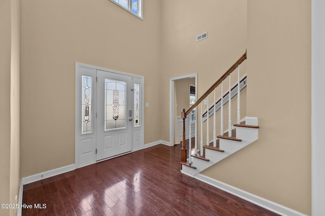 entryway with a towering ceiling and hardwood / wood-style floors