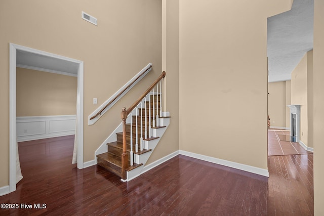 stairs featuring crown molding and wood-type flooring