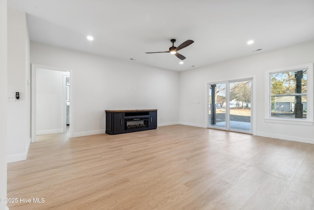 unfurnished living room with ceiling fan and light wood-type flooring