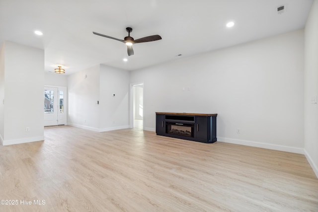 unfurnished living room featuring ceiling fan and light hardwood / wood-style floors