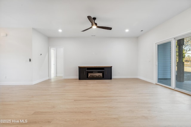 unfurnished living room featuring ceiling fan and light hardwood / wood-style floors