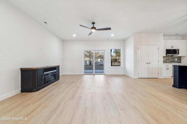 unfurnished living room with ceiling fan and light hardwood / wood-style floors