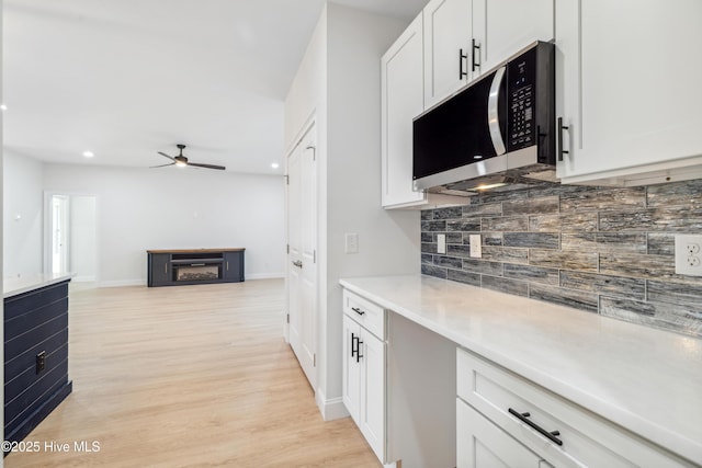 kitchen with white cabinetry, ceiling fan, tasteful backsplash, and light hardwood / wood-style flooring