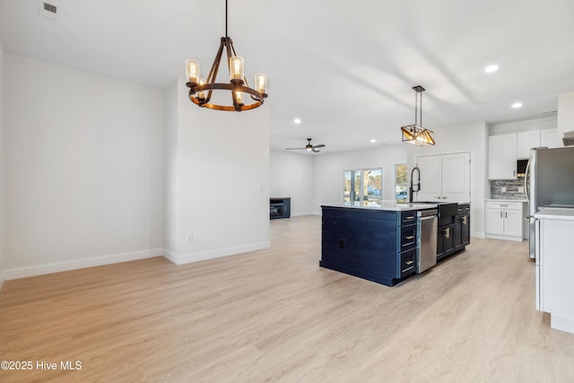 kitchen featuring tasteful backsplash, hanging light fixtures, light hardwood / wood-style floors, and white cabinets