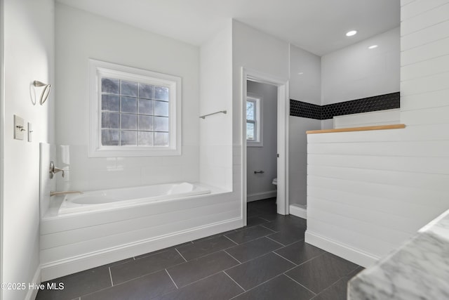 bathroom with a bathing tub and tile patterned floors