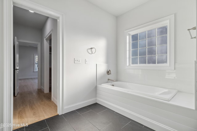 bathroom with a washtub and tile patterned floors