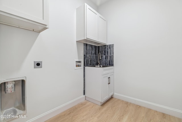 clothes washing area featuring hookup for an electric dryer, hookup for a washing machine, sink, and light hardwood / wood-style flooring