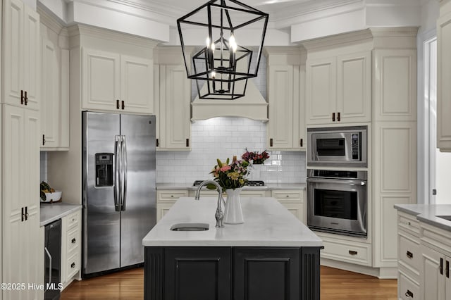 kitchen with appliances with stainless steel finishes, a center island with sink, decorative light fixtures, backsplash, and wine cooler