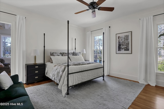 bedroom featuring hardwood / wood-style floors, multiple windows, and ceiling fan