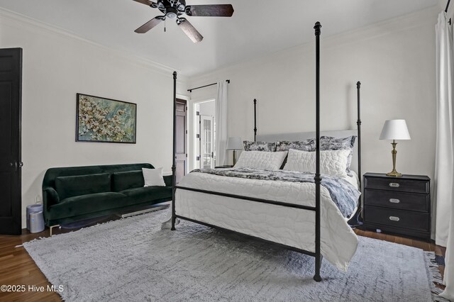 bedroom with dark wood-type flooring, crown molding, and ceiling fan