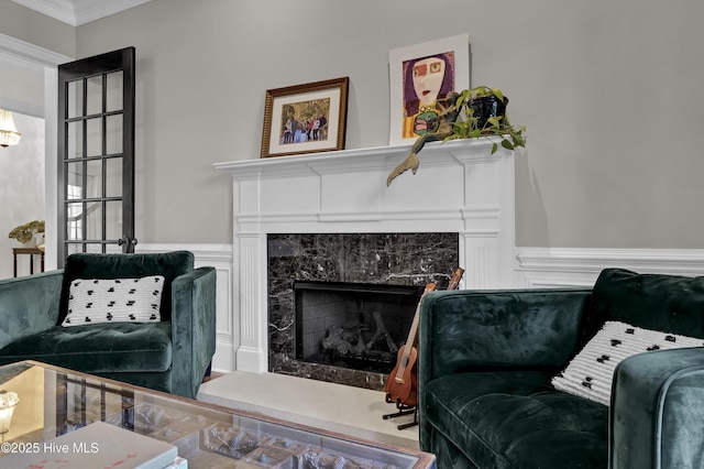 sitting room with crown molding and a premium fireplace