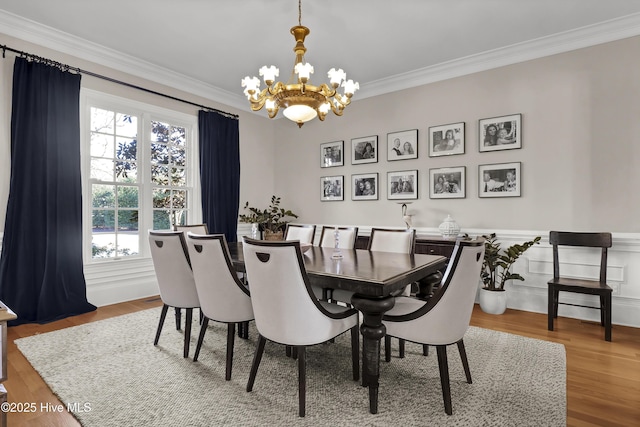 dining room with a notable chandelier, ornamental molding, and hardwood / wood-style floors