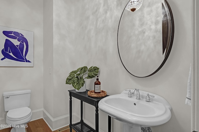 bathroom with sink, toilet, and hardwood / wood-style flooring