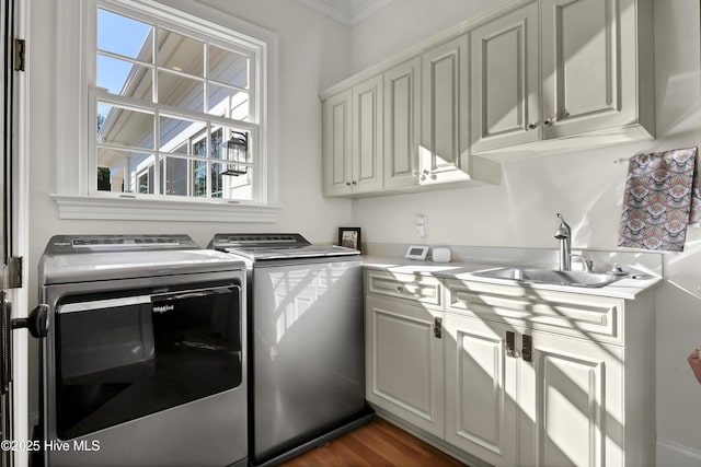 laundry room with cabinets, washing machine and dryer, sink, and dark wood-type flooring