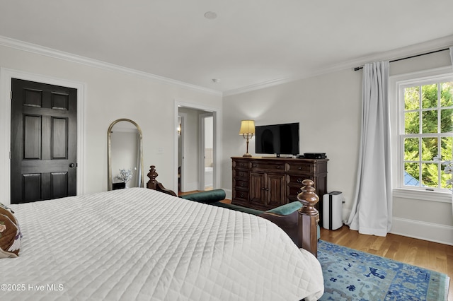 bedroom with light hardwood / wood-style flooring, crown molding, and multiple windows