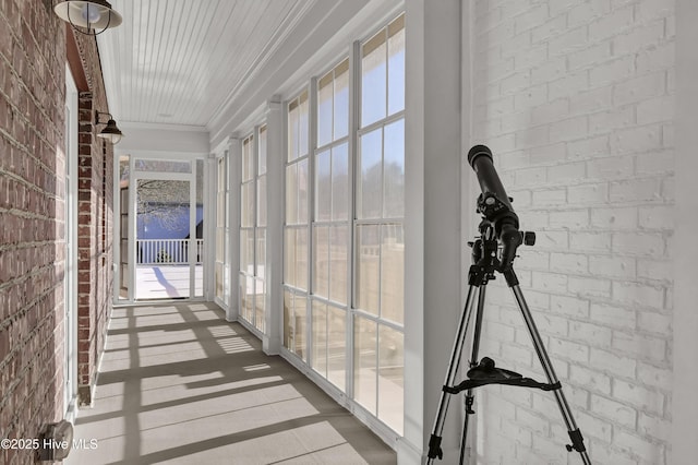 hallway with brick wall and ornamental molding