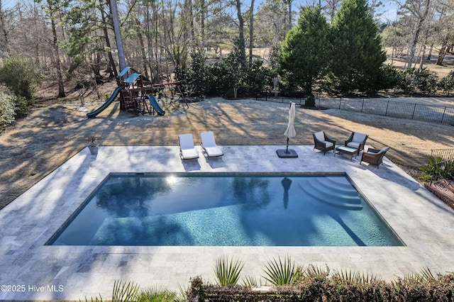 view of swimming pool with a playground and a patio area