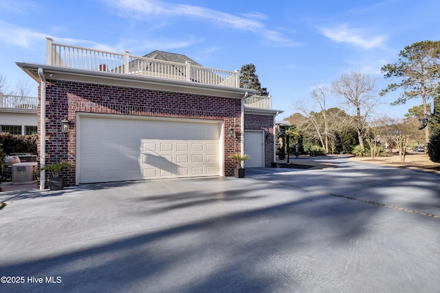 view of home's exterior with central AC, a garage, and a balcony