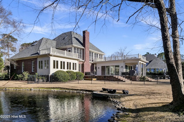 back of property featuring a water view and a balcony