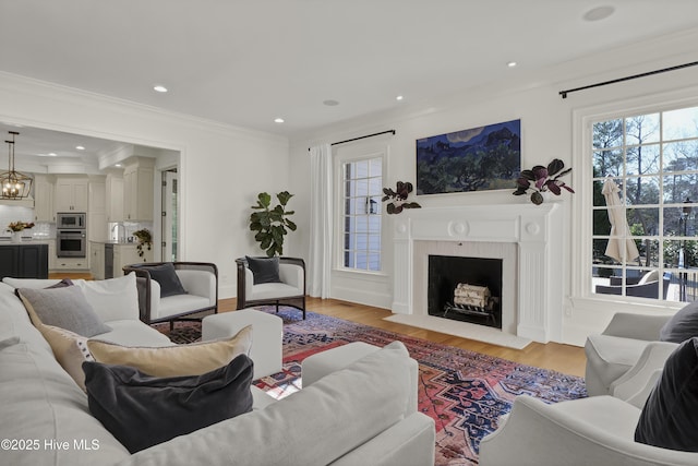 living room featuring plenty of natural light, crown molding, and light hardwood / wood-style flooring