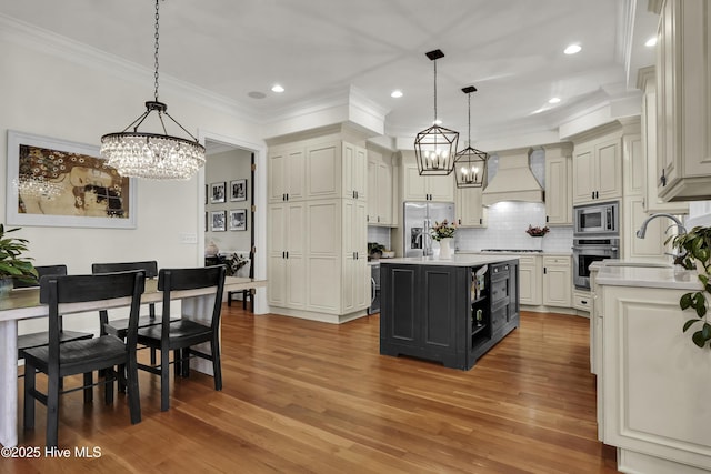 kitchen with hanging light fixtures, a center island, appliances with stainless steel finishes, and custom exhaust hood