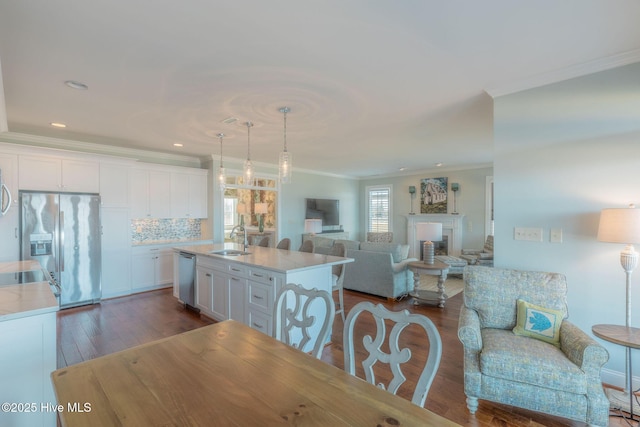 kitchen featuring sink, decorative light fixtures, white cabinets, and appliances with stainless steel finishes