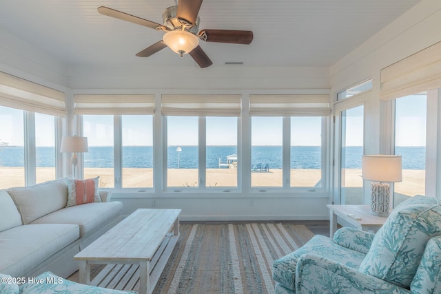 sunroom with a beach view and a water view