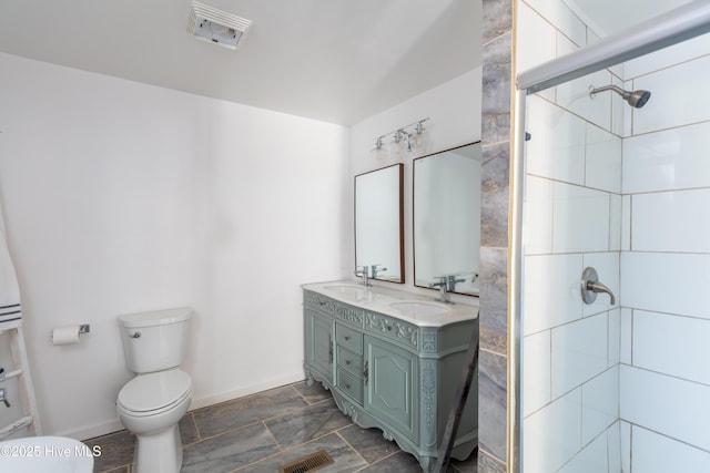 bathroom with toilet, an enclosed shower, and vanity