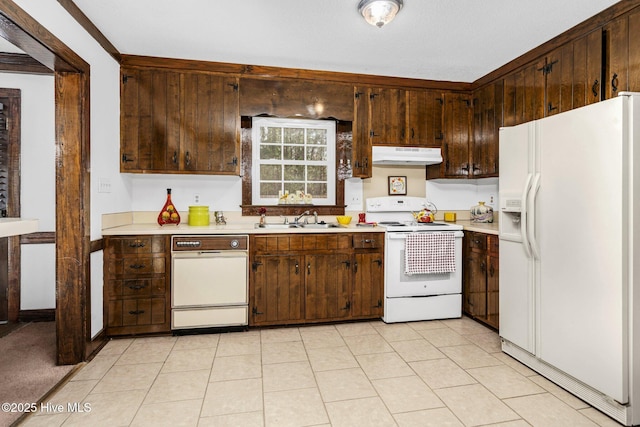 kitchen featuring white appliances, sink, and dark brown cabinetry