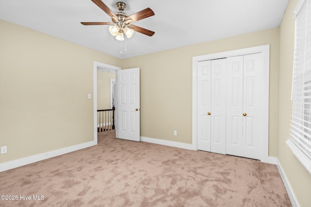 unfurnished bedroom with ceiling fan, a closet, and light carpet