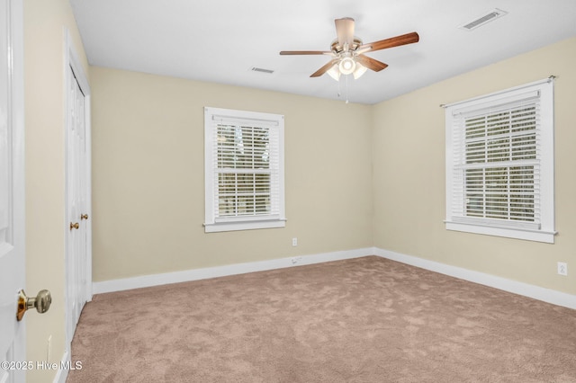 carpeted spare room featuring ceiling fan