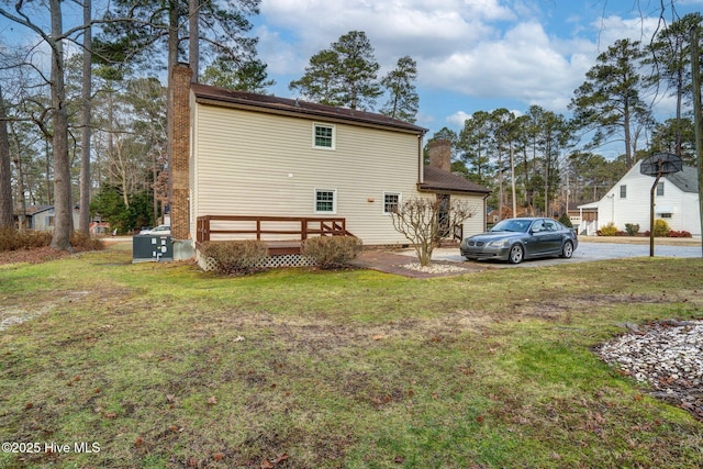 rear view of house featuring a yard and a deck