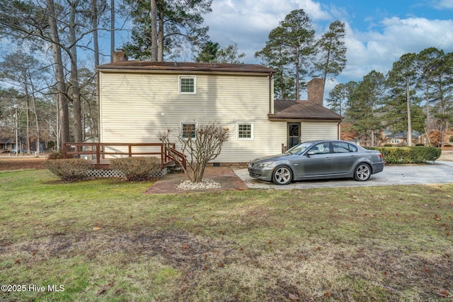 back of house with a lawn and a deck