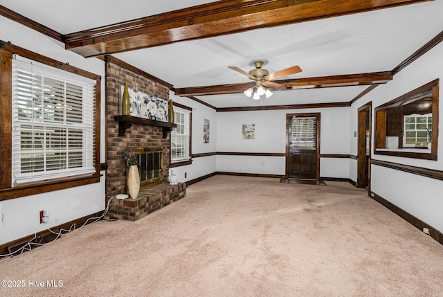 unfurnished living room featuring a fireplace, ceiling fan, crown molding, and carpet