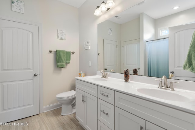 bathroom with toilet, vanity, hardwood / wood-style floors, and walk in shower