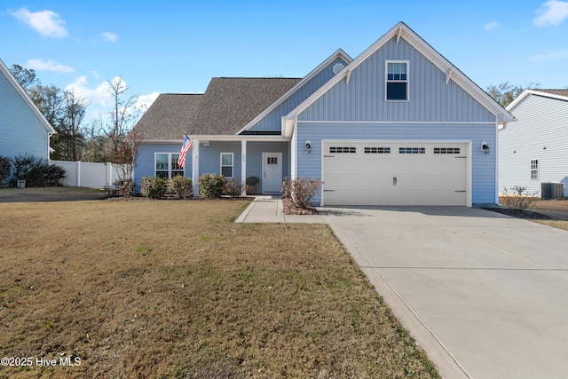 view of front of house with a front yard, a garage, and central AC unit