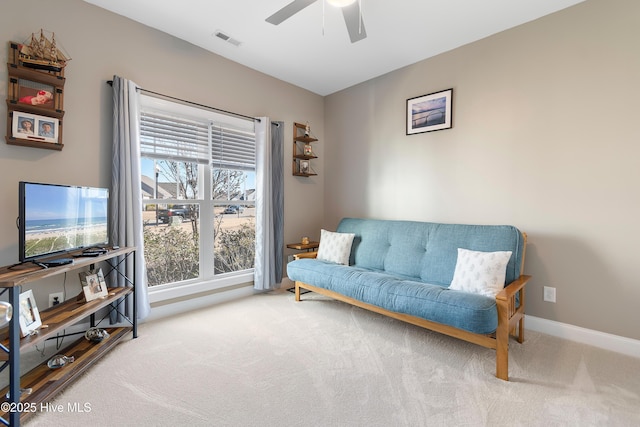 living area with ceiling fan and light carpet