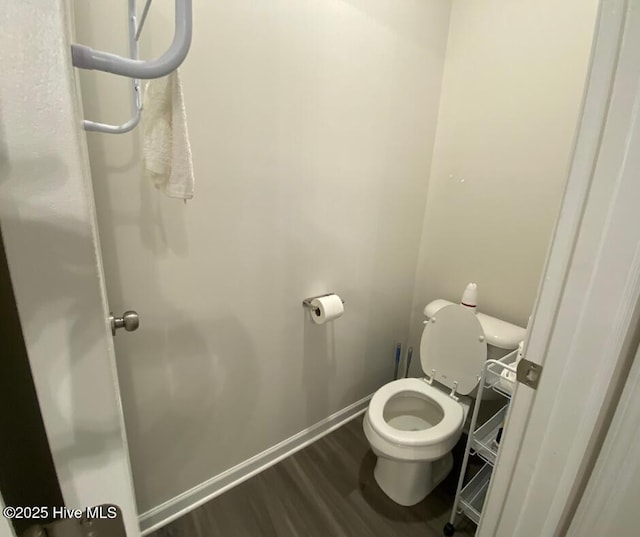 bathroom with toilet and wood-type flooring