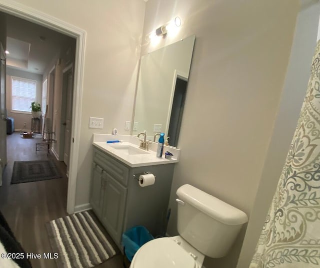 bathroom with toilet, vanity, and hardwood / wood-style flooring