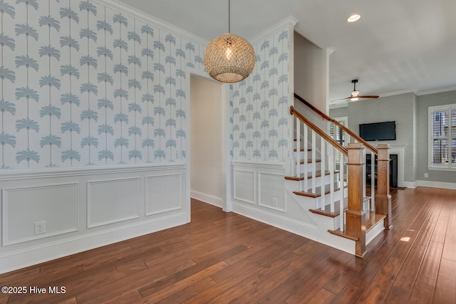 stairs featuring ceiling fan, hardwood / wood-style floors, and crown molding