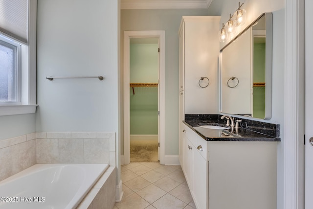 bathroom featuring a spacious closet, tile patterned flooring, a garden tub, and vanity