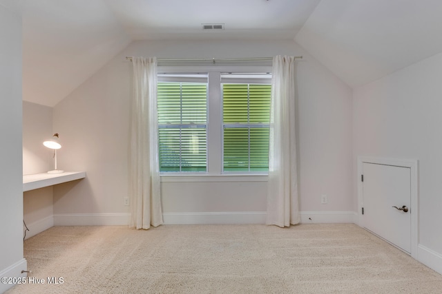 additional living space with lofted ceiling, visible vents, and carpet flooring