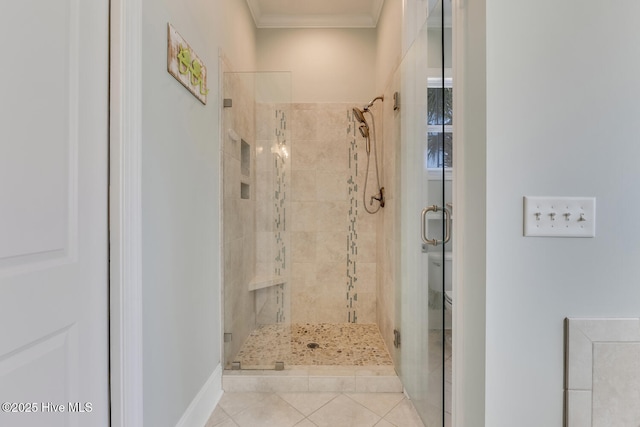 full bath featuring a shower stall, crown molding, and tile patterned floors